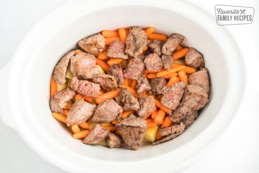 Potatoes, carrots, and beef in a white crock pot