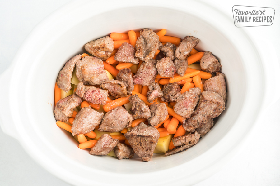 Potatoes, carrots, and beef in a white crock pot