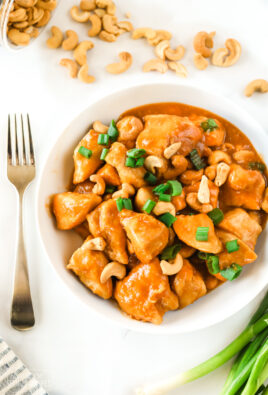 Cashew Chicken in a bowl next to cashews and green onion