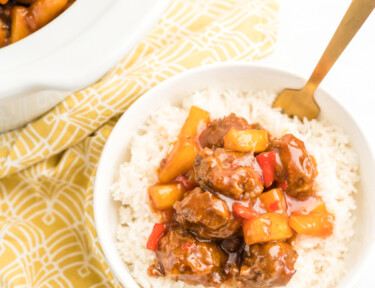 A bowl of rice topped with sweet and sour meatballs