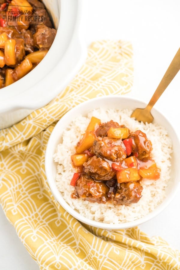A bowl of rice topped with sweet and sour meatballs