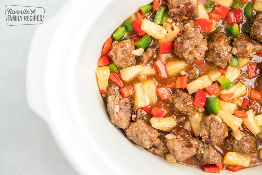 Meatballs, pineapple, peppers, and sauce in a crock pot