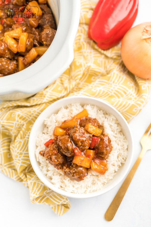 A bowl of rice topped with sweet and sour meatballs