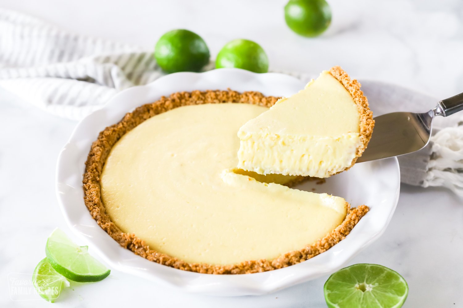 A plain slice of key lime pie being lifted from a pie pan with a pie knife