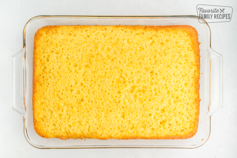 A lemon cake in a glass baking dish with the top leveled