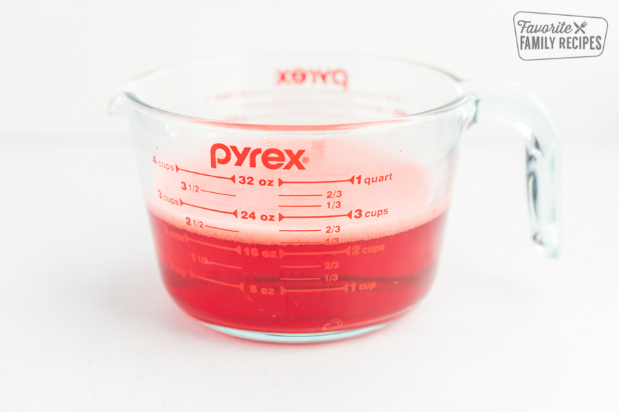 Raspberry jello in a glass measuring cup