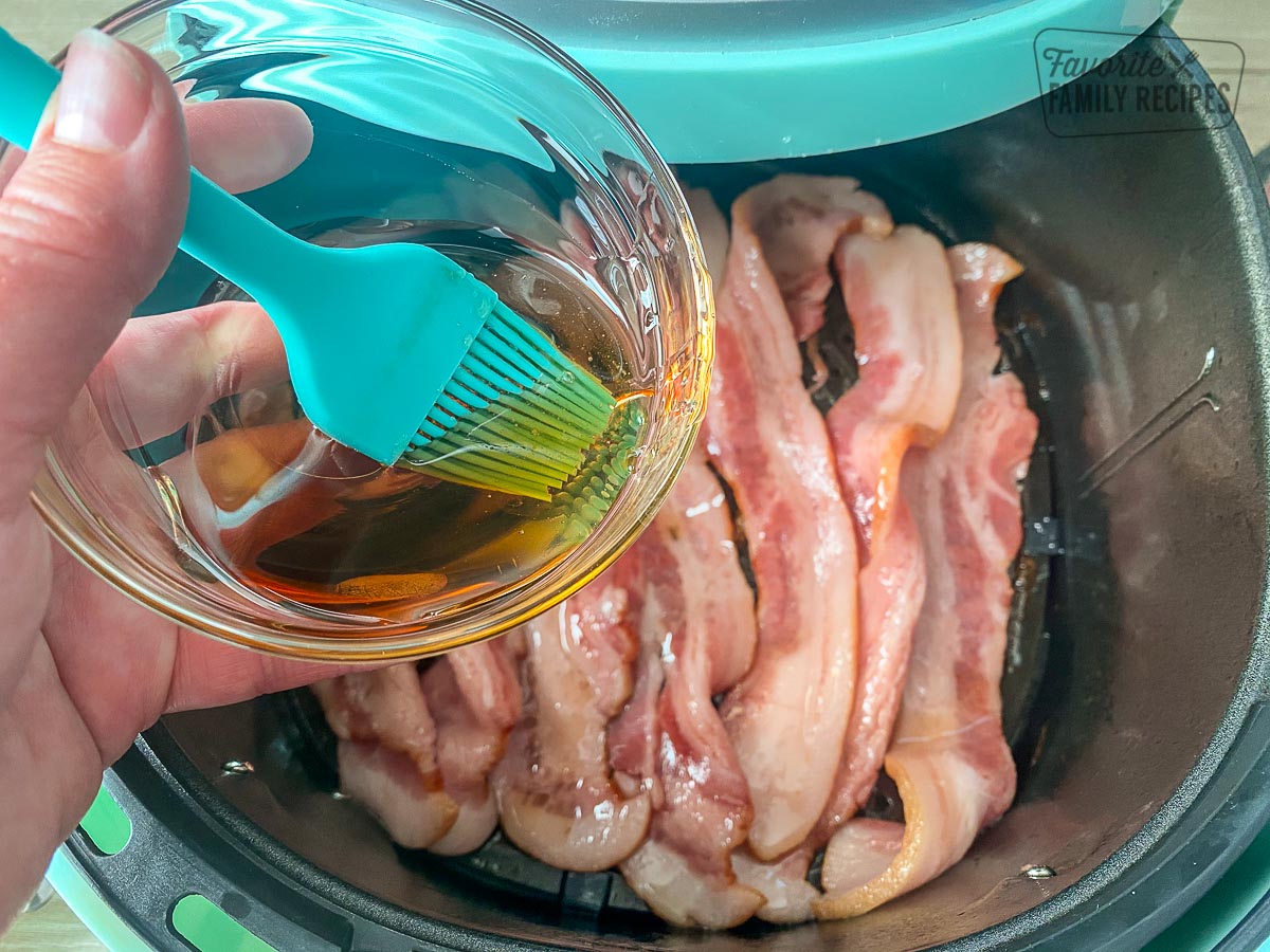 Brushing maple syrup onto bacon