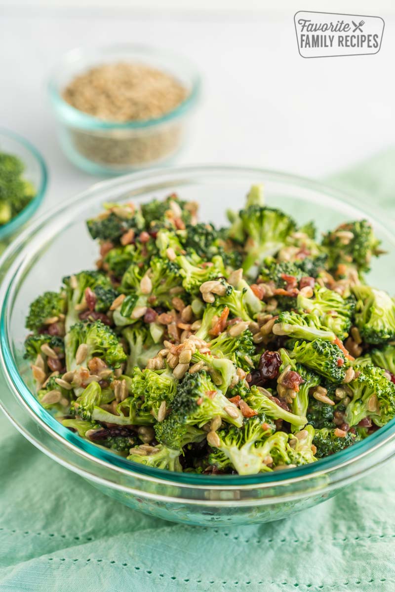 Broccoli Salad in a clear bowl with bacon and sunflower sprinkled on top