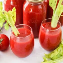 Two glasses of tomato juice and three quart jars of canned tomato juice