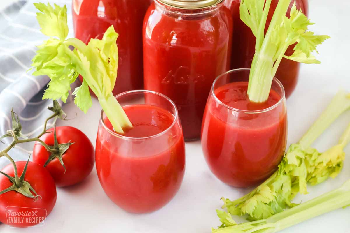 Two glasses of tomato juice and three quart jars of canned tomato juice