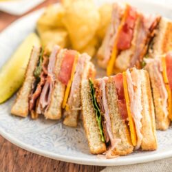 Quarters of a club sandwich served on a lunch plate