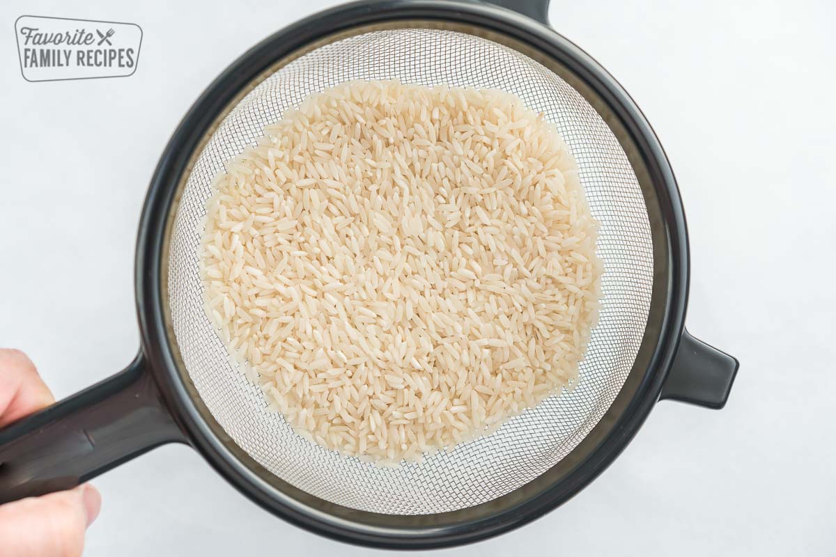 Uncooked rice in a fine mesh strainer