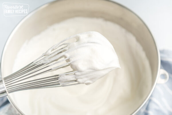 A whisk covered in whipped cream