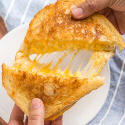 A grilled cheese sandwich being pulled apart