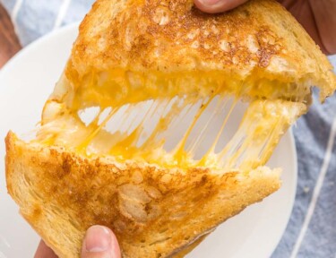 A grilled cheese sandwich being pulled apart