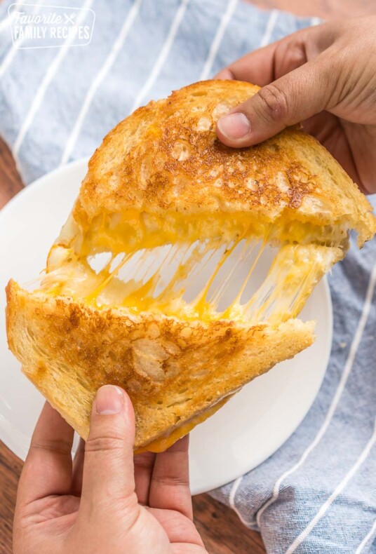 A grilled cheese sandwich being pulled apart