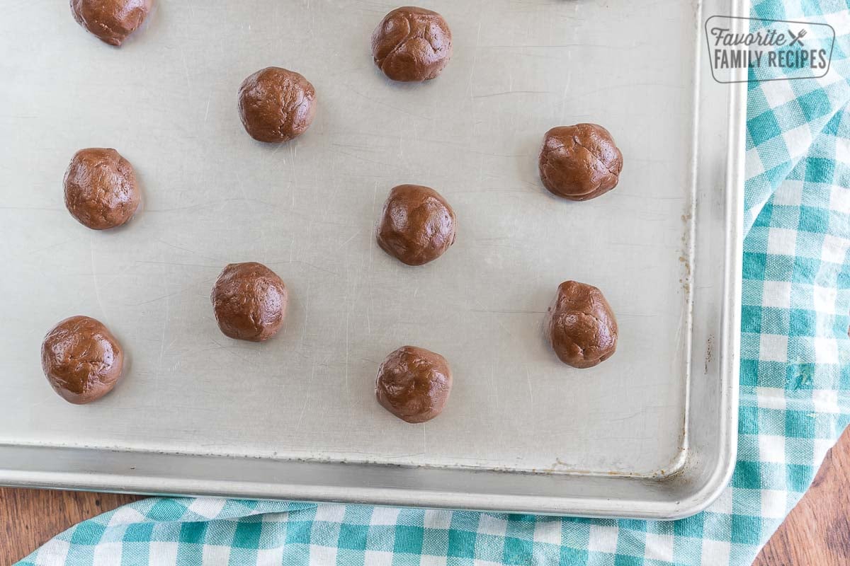 Cookie batter rolled into balls on a baking sheet.