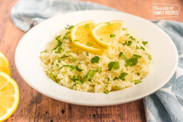 lemon rice in a white bowl topped with lemon slices
