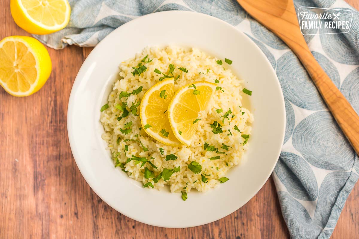 Lemon rice in a white bowl topped with lemon slices