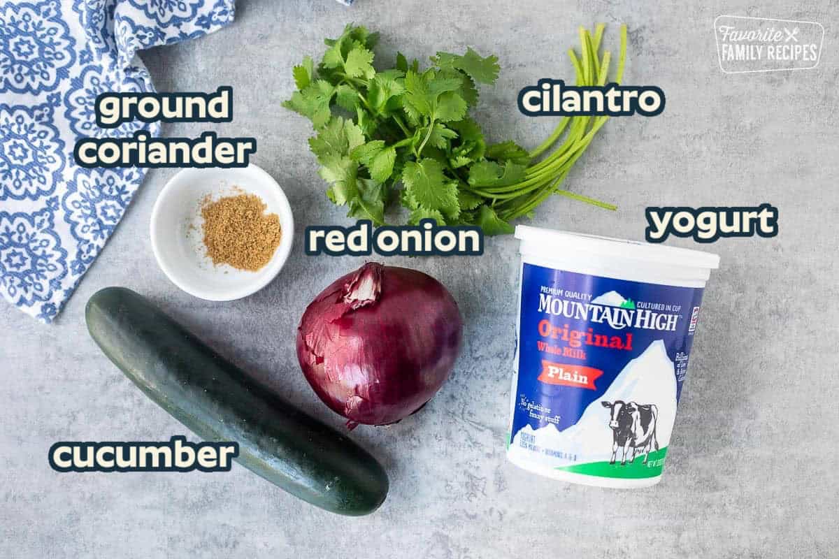Ingredients to make raita: yogurt, cucumber, cilantro, red onion, ground coriander