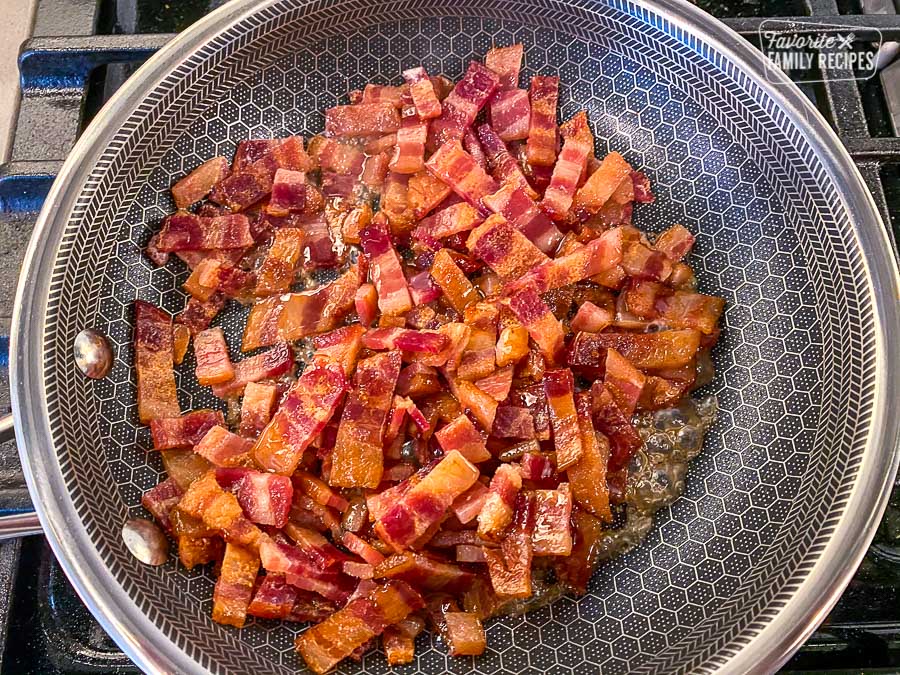 Bacon pieces cooking in a fry pan