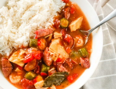 A bowl of Instant Pot Gumbo with white rice on the side