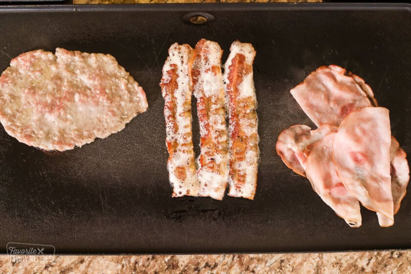 Sausage, bacon, and ham on a griddle