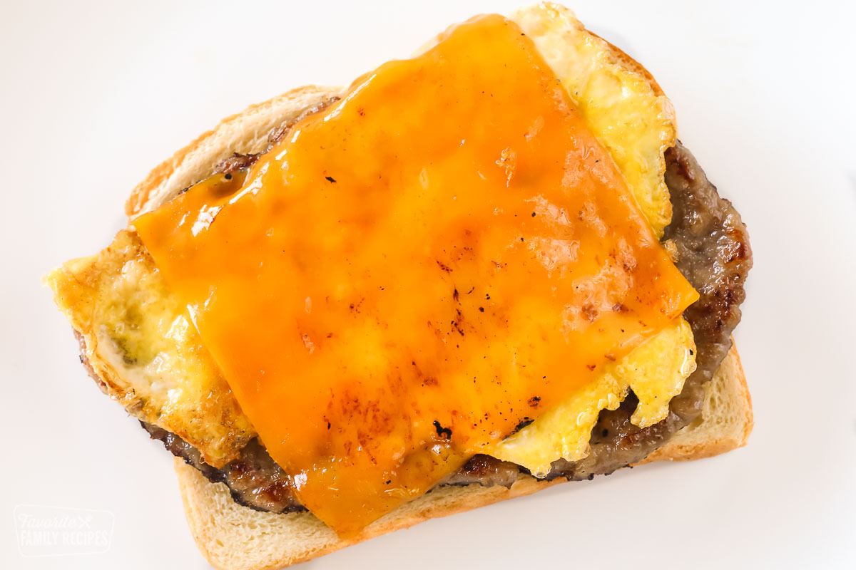Sausage, egg, and cheddar cheese on an open-faced toast.