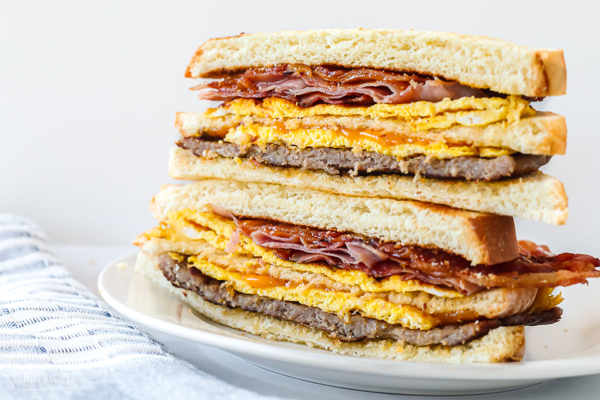 A breakfast sandwich halved with the halves stacked on top of one another.