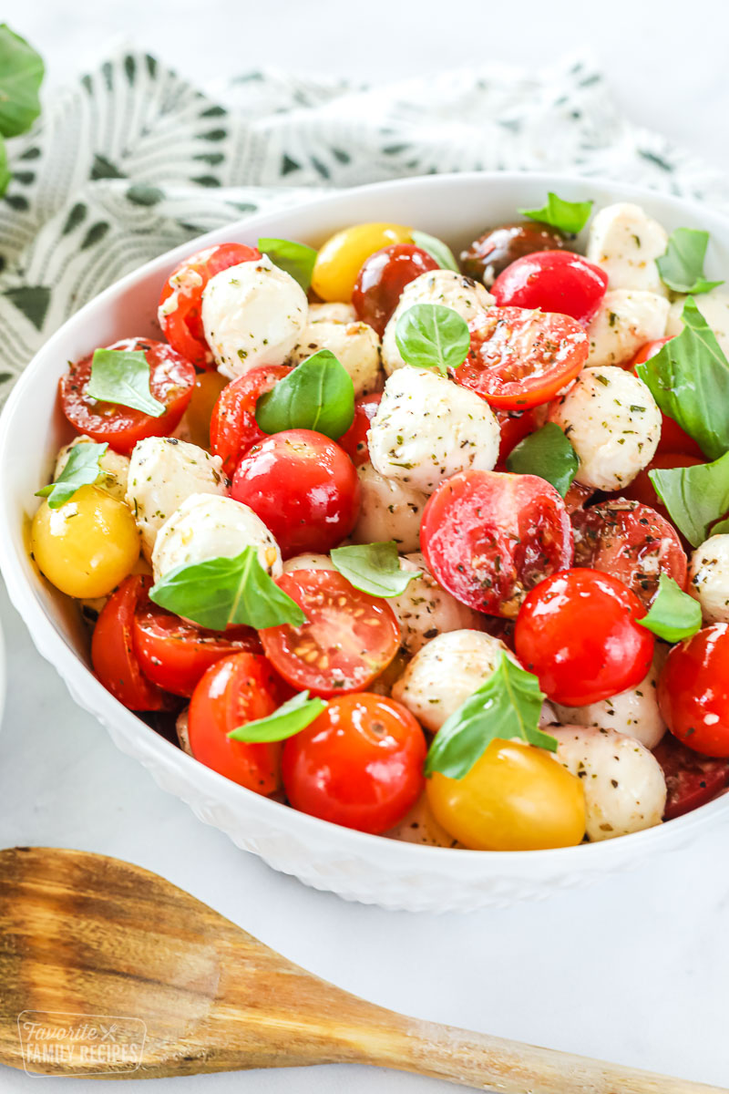 A plate with cherry tomatoes, mozzarella, basil, olive oil, and a drizzle of balsamic vinegar reduction.