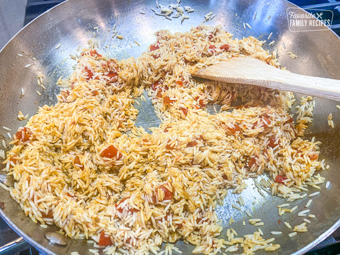 Adding Rice to the tomatoes and spices in the fry pan