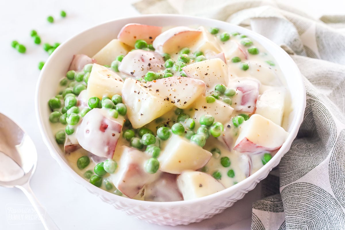 A bowl of creamed peas with potatoes.