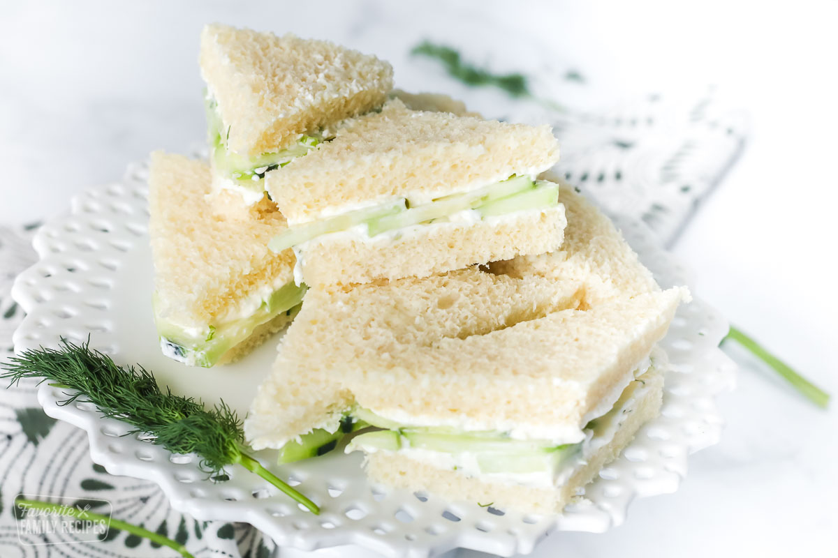 Cucumber sandwiches cut into triangles and stacked on a serving platter