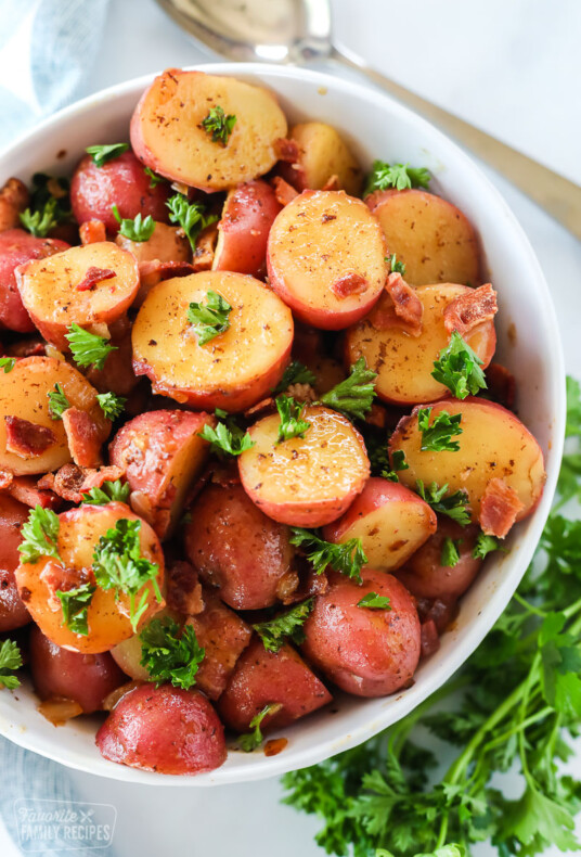 German potato salad made with red potatoes, vinegar, onion, bacon, and parsley in a bowl.