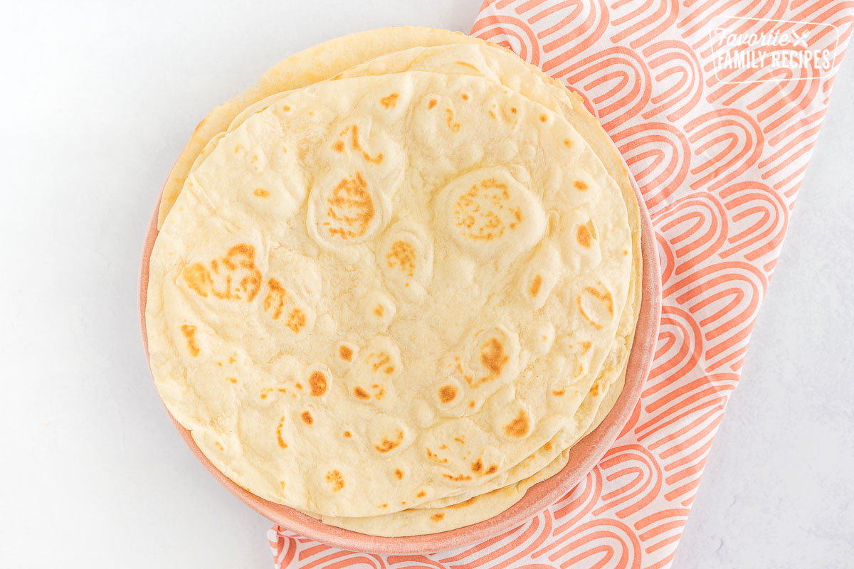 A stack of tortillas on a pink plate