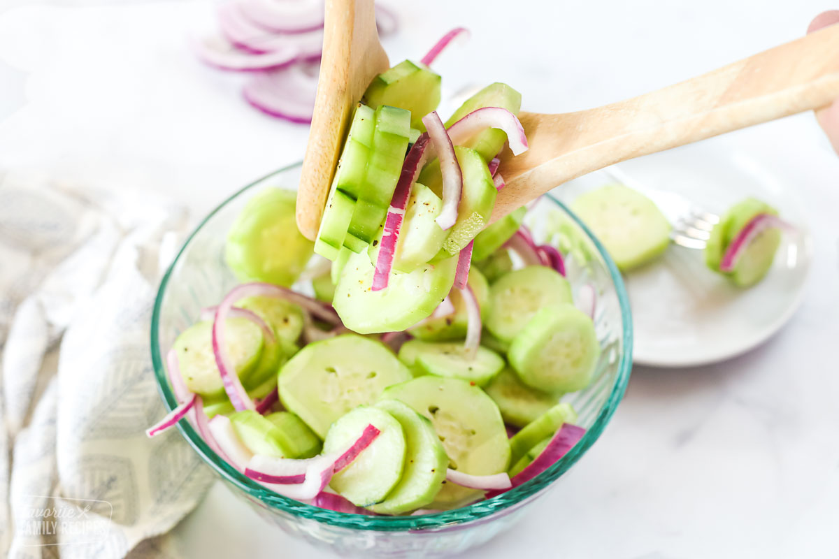 Cucumbers marinated in vinegar in a bowl with red onion slices