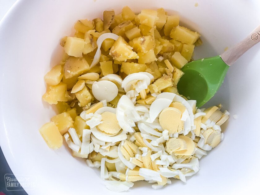 Cooked, diced potatoes and chopped hard boiled egg in a bowl