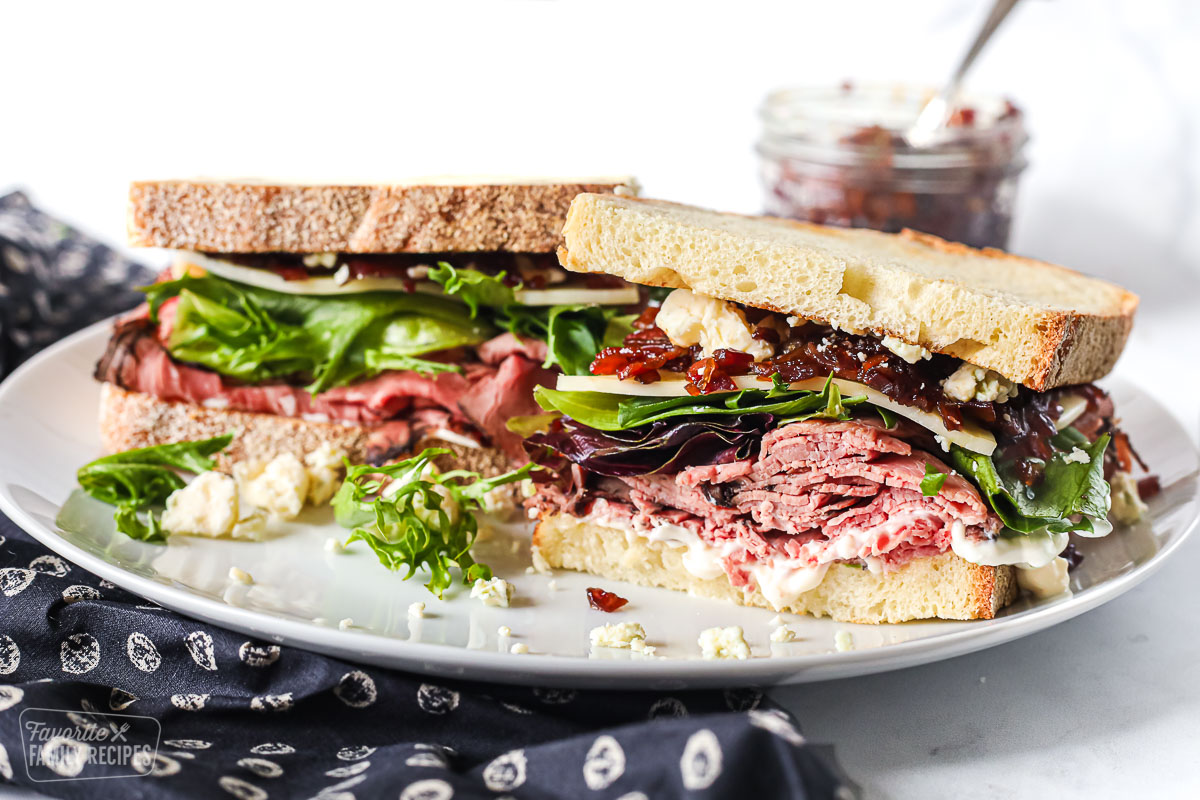 Roast beef sandwich cut in half to show beef and toppings.