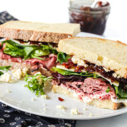 A roast beef sandwich with deli roast, lettuce, cheese, and bacon jam.