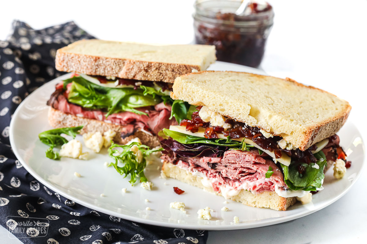 A roast beef sandwich with deli roast, lettuce, cheese, and bacon jam.