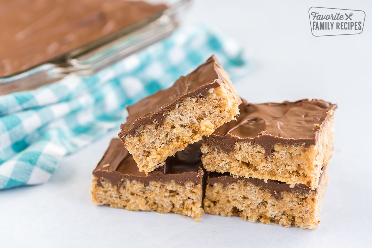These no-bake Scotcharoos, also known as Oh Henry Bars, are a favorite treat. A Rice Krispie and peanut butter center is covered with a chocolate butterscotch topping. A stack of scotcharoos.