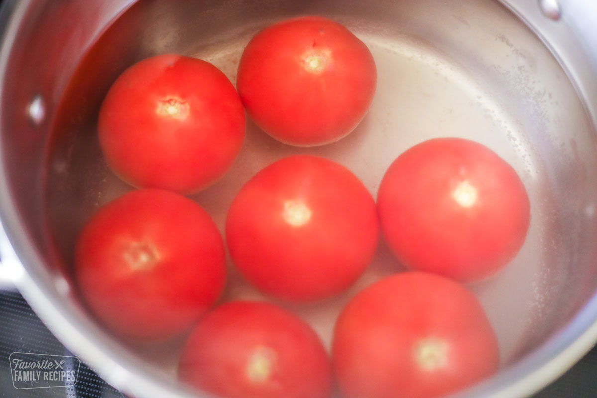 Seven tomatoes in a pot of boiling water