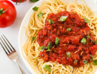 A bowl of spaghetti topped with spaghetti sauce made from scratch