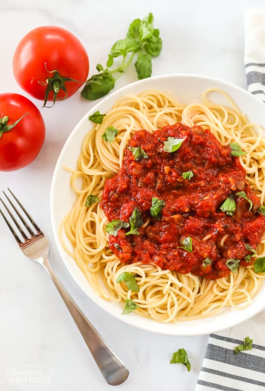 A bowl of spaghetti topped with spaghetti sauce made from scratch