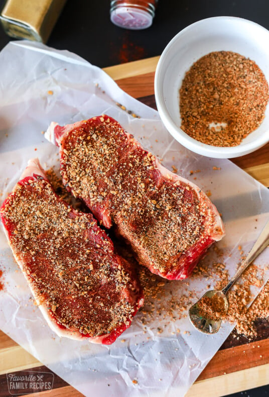 Two cuts of steak with dry rub on them.