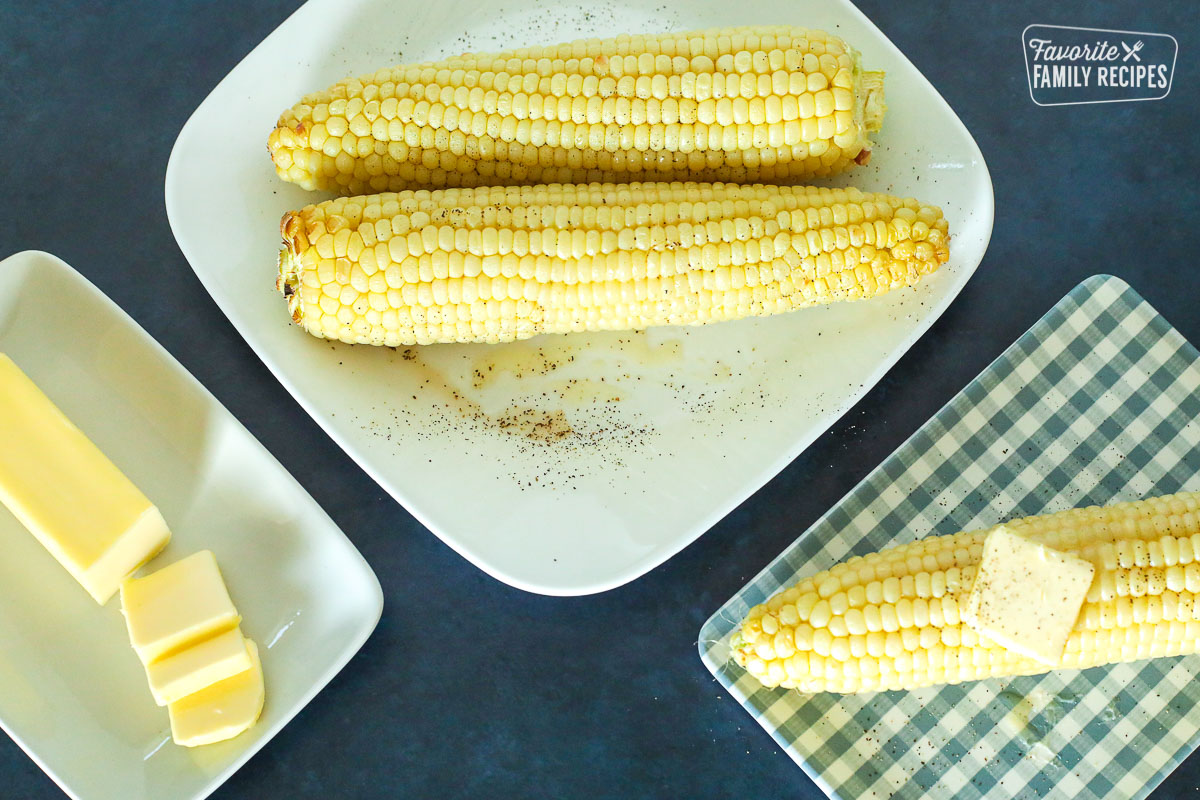 A plate of cooked Air Fryer Corn on the Cob with a side of butter
