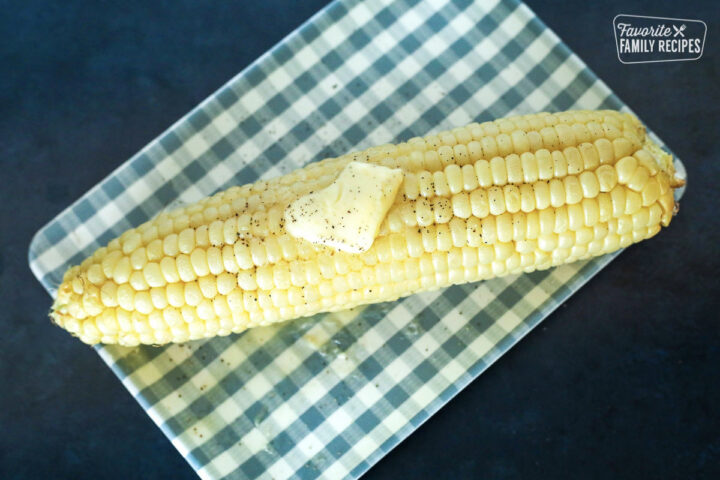 Cooked Air Fryer Corn on the Cob on a plate with a slice of butter