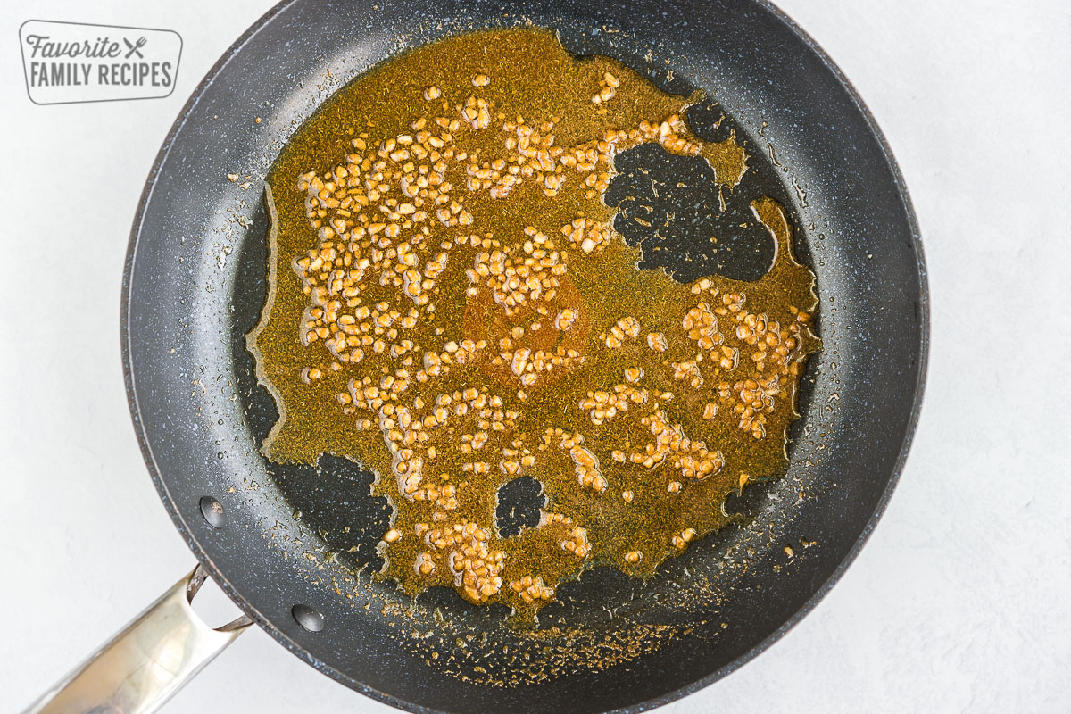 Garlic and spices in oil cooking in a pan