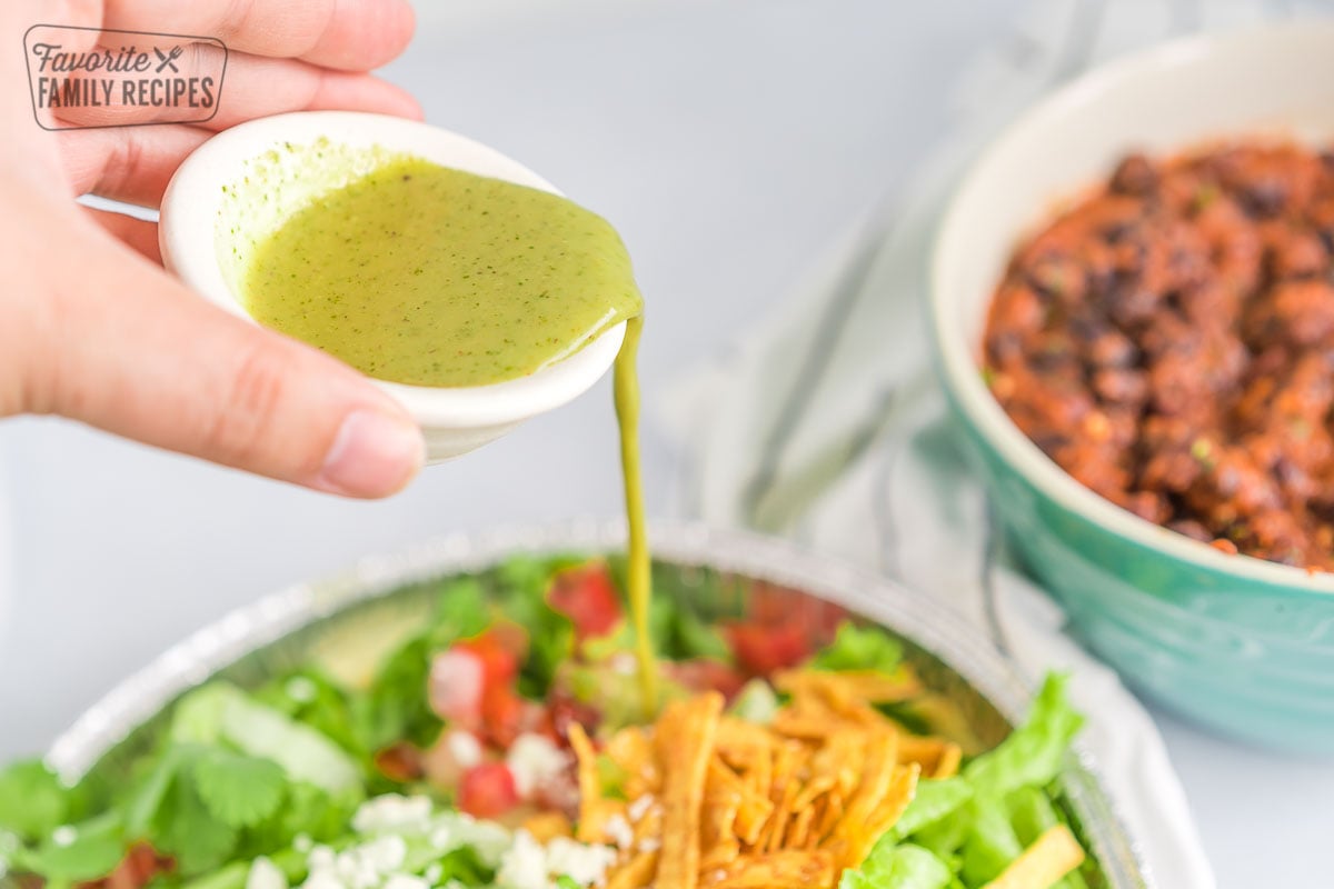 Dressing being poured over a salad