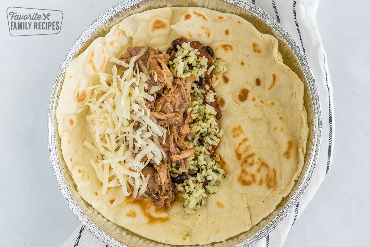 A tortilla filled with rice, beans, pork, and cheese